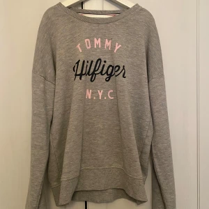 Grå Tommy Hilfiger tröja.  - Den är ganska andvänd och därför är den lite urtvättad men det märks inte.
