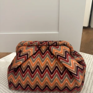 Färgglad mönstrad väska - Säljer en färgglad väska med zigzag-mönster. Den är från BECK SÖNDERGAARD. Man får plats med allt man behöver, knappas använd. Perfekt för att ge en färgklick till din outfit!