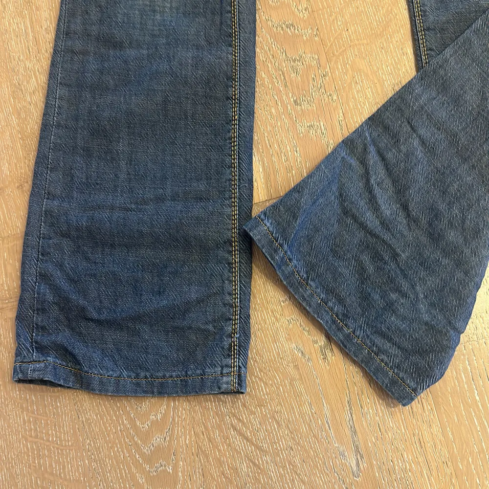 Snygga blå jeans från Lee med klassisk femficksdesign och orange sömmar💕De har en knappgylf och bälteshällor, perfekt för en avslappnad stil😊 Passformen är rak och de är tillverkade i slitstarkt denim. Inga slitningar alls🩷. Farkut & Housut.