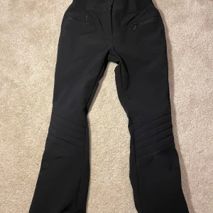 Svarta Skidbyxor från 8848! -  Snygga trendiga svarta skidbyxor med bootcut-stil. De sitter jättesnyggt på och är perfekta för en stilren look på skidsemestern! Storlek är 38, men har stretchig midja och är små i storleken. Passar både xs och s. Innerbenslängd 75cm. De har i princip inga tecken på användning. Skriv vid funderingar!❄️💞