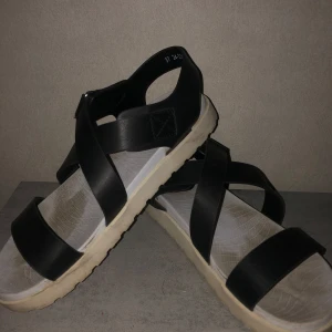 Svarta sandaler med remmar - Snygga svarta sandaler med breda remmar och bekväm sula. Perfekta för varma sommardagar. Stilren design som passar till många olika outfits.