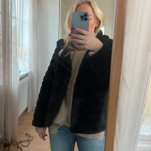 Svart pälsjacka med luva  - Pälsjacka i väldigt fint skick med luva, använd fåtal gånger.