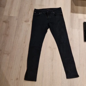 Nudie jeans  - Snygga svarta jeans från Nudie Jeans med en klassisk femficksdesign. De har en dragkedja och knapp framtill samt Nudie Jeans logotyp på baksidan. Perfekta för en stilren look. Väldigt lätta att styla. 