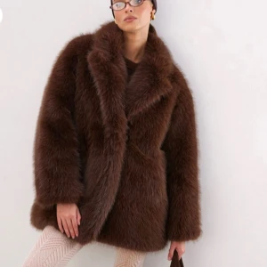 Brun pälsjacka - Säljer en lyxig brun pälsjacka med en elegant och fluffig design. Jackan har en oversized passform och långa ärmar, perfekt för att hålla dig varm och stilren under kalla dagar. Den är tillverkad i ett mjukt och bekvämt material som ger en exklusiv känsla. Helt ny aldrig använd, då jag råkade beställa två st .