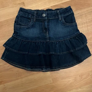 Mörkblå jeanskjol med volang - Super fin low waist jeanskjol köpt på second hand men som tyvärr inte passa! Lappen har trillat av men skulle säga att den passar som XS. Köp sker via köp nu. Skriv vid frågor! 
