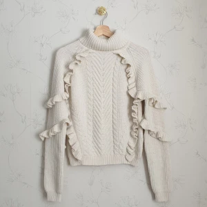 Stickad chunky volang tröja - 🧁FÖRST TILL KVARN!🧁 Stickad chunky tröja med volanger i krämvit färg. Från märket Glamorous. Så chic och lyfter fram den vardagliga looken ett extra steg. Perfekt för när vädret är kyligare men man vill fortfarande se söt ut och hålla sig varm. Vill bli av med ASAP🩷