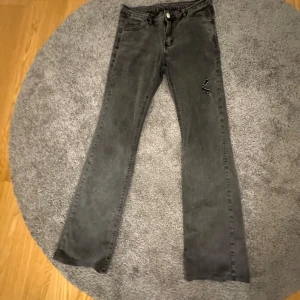 Grå jeans med bootcut - Snygga grå jeans med bootcut-stil. De har en klassisk femficksdesign och en liten reva på ena benet för en trendig look. 