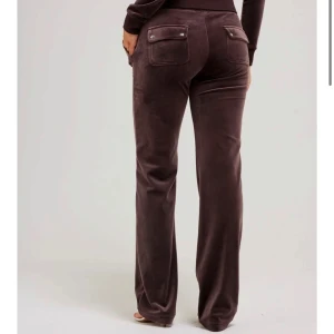 Juicy Couture byxor - Snygga bruna mjukisbyxor i ett mjukt material med fickor fram och bak. Byxorna har en avslappnad passform och dragsko i midjan för extra komfort. 