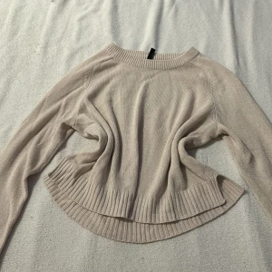 Beige stickad tröja från Divided - Säljer en stilren beige stickad tröja från Divided. Tröjan har långa ärmar och ribbade detaljer vid hals, ärmslut och nederkant. Perfekt för kyligare dagar. Hör av dig vid intresse! 😊Storlek L men är mer som S