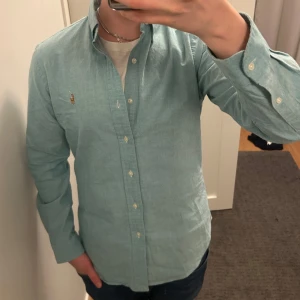 Ralph Lauren Skjorta - Säljer nu en riktigt fet Ralph Lauren skjorta i Storlek M/S och Färg turkos/ljusblå. Skjortan har inga defekter och är väl omtagen (som ny). Snabb affär bättre pris. Om du har några funderingar så är det bara att fråga på!❇️