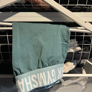 Gröna shorts  från Gymshark - Säljer gröna shorts  från Gymshark med elastisk kant. Perfekt för träning eller en avslappnad dag. Shortsen har en stilren design och är gjord i ett mjukt material.