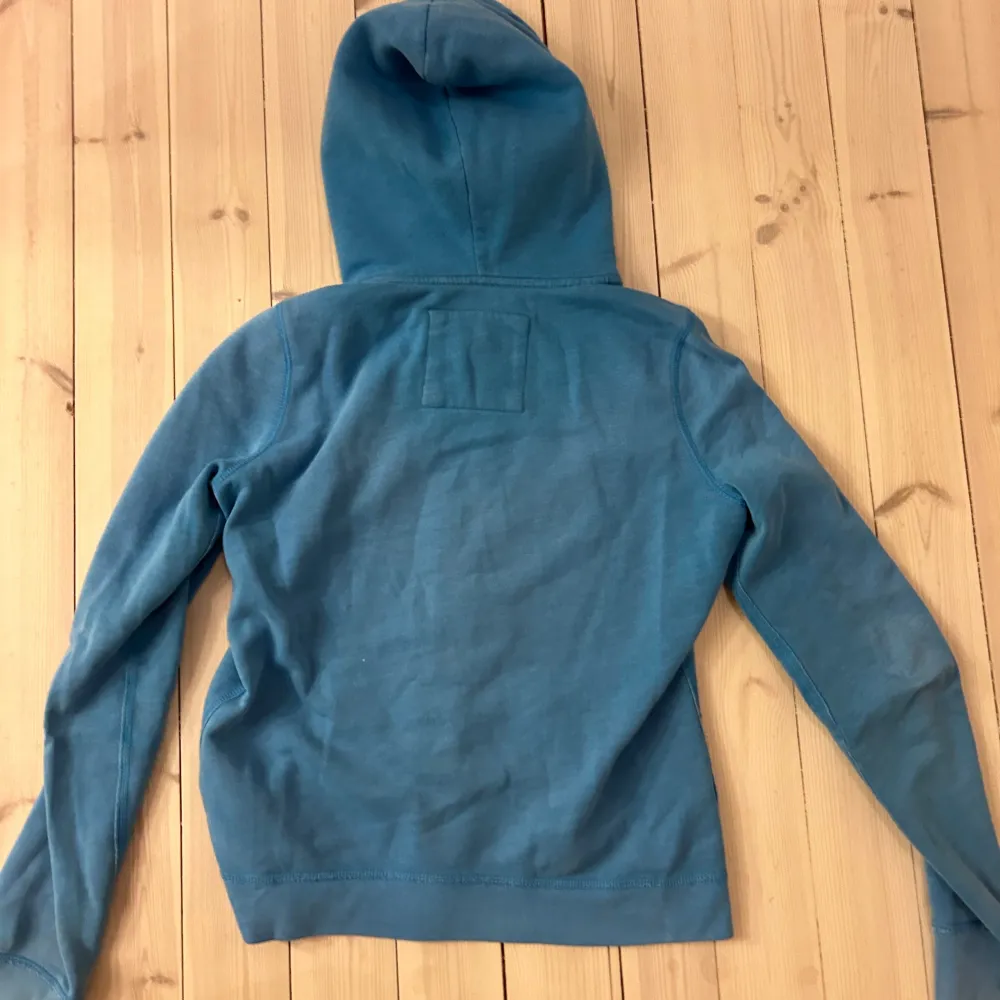 Blå zip-up hoodie från Hollister! Säljer då den ej kommer till användning 💕. Neuletakit & Villapaidat.