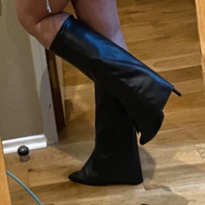 Svarta höga stövlar - Snygga svarta höga stövlar i skinn med spetsig tå och klack. Perfekta för en stilren look.