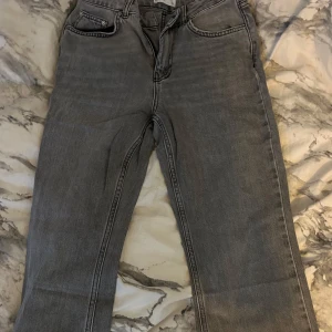 Grå jeansbyxor - Snygga grå jeansbyxor med klassisk design. Perfekta för en avslappnad stil. De har en rak passform och traditionella fem fickor.