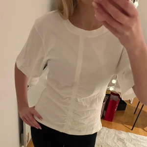 Vit T-shirt från & other stories - Stilren vit T-shirt från & other stories. I ny skick, passar både till vardags och uppklädda tillfällen.