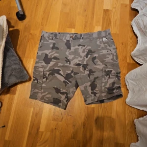 Camouflage shorts med fickor - Snygga camouflage shorts i grå toner. Perfekta för en avslappnad stil. 
