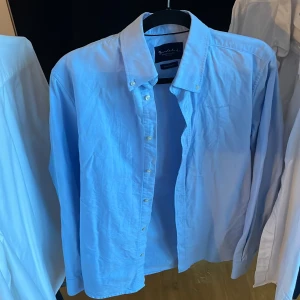 Ljusblå skjorta från Bondelid - Snygg ljusblå skjorta från Bondelid med klassisk krage och knappar framtill. Perfekt för en stilren look. Skjortan har en normal tailored fit.