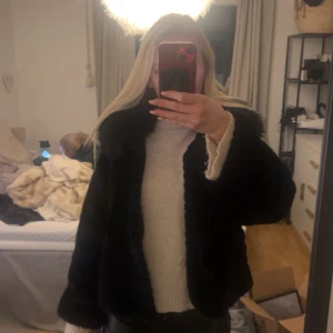 Svart pälsjacka - Säljer en svart pälsjacka med fluffig krage. Jackan har en lyxig känsla. Den är långärmad och har en stilren design som passar till många olika outfits. Jag älskade den men har köpt en annan jacka. Orginalpris 900