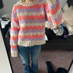 Färgglad stickad tröja från Mango - Säljer en mysig stickad tröja från Mango i storlek L men passsar för S.  Tröjan har ett randigt mönster i lila, rosa och beige med långa ärmar och ribbade kanter. Super fin vinter/höst tröja som är super skön! Kan diskutera pris!