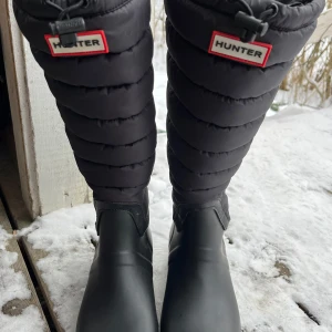 Svarta stövlar från Hunter - Säljer ett par svarta stövlar från Hunter med quiltad design och justerbar dragsko upptill. Perfekta för kallare dagar. 