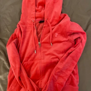 Juicy couture överdel i fint skick - Snygg rosa hoodie med dragkedja och huva. Den har en broderad logga på bröstet och praktiska fickor framtill. Perfekt för en avslappnad stil.