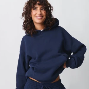 Mörkblå Gina hoodie  - Säljer en mörkblå hoodie med en klassisk design. Den har en stor ficka framtill och en bekväm huva. Perfekt för en avslappnad stil. Storlek S fint skick!❤️