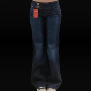 Mörkblå jeans med bootcut - Snygga mörkblåa jeans. De har en låg midja och stängs med dragkedja och två knappar. Jätte fina men säljs eftersom de knappt används.