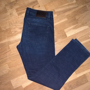 Diesel Jeans  - Snygga blå jeans från Diesel med klassisk femficksdesign och en mörk tvätt. Perfekta för en avslappnad stil. Märkeslogga på baksidan och knappgylf framtill.