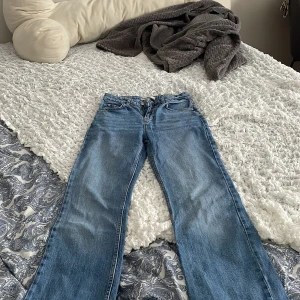 Blå jeans från Denim Rebel - Snygga blå jeans från Denim Rebel med klassisk femficksdesign och knappgylf. Perfekta för en avslappnad stil med en rak passform som ger en tidlös look.