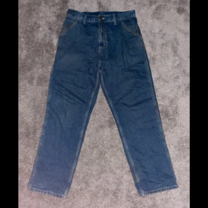 Blå baggy Carhartt jeans - Riktigt feta baggy jeans, pytte lite slitage vid benöppningen och ytterst lite i fram fickorna. 30/32 kom med bud
