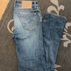 Blå jeans från Jacob Cohen - Jacob cohen jeans i topp skick med snygga slitningar. 30/32 slim fit. Beige hästskinn på baksidan och många små detaljer 