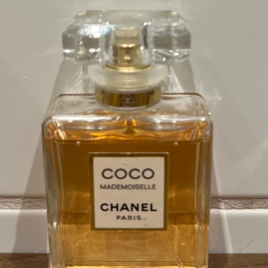 Coco Mademoiselle Parfym från Chanel - Elegant parfymflaska från Chanel med den ikoniska doften Coco Mademoiselle. Flaskan är rektangulär med en klar glasdesign och en stilren etikett. Perfekt för den som älskar lyxiga och tidlösa dofter. 35ml, använd ett fåtal gånger. Nypris 1098kr.