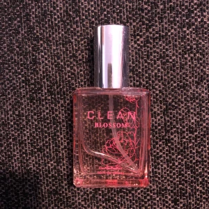 Clean Blossom Parfym - Säljer en fräsch och blommig parfym från Clean i doften Blossom. Flaskan är rektangulär med rosa toner och har ett stilrent silverlock. Perfekt för dig som älskar lätta och naturliga dofter. Har använt lite (se bild) 