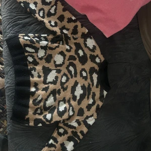 Leopardmönstrad tröja med svarta detaljer - Säljer en cool leopardmönstrad tröja med svarta muddar och krage. Tröjan har långa ärmar och är supermjuk och bekväm. Tröjan är köpt second hand för ca 2 år sen och lappen var avklippt så vet tyvärr inte märket men skulle uppskatta att tröjan är storlek S 💗använt mindre än 10 gånger och den är i fint skick!