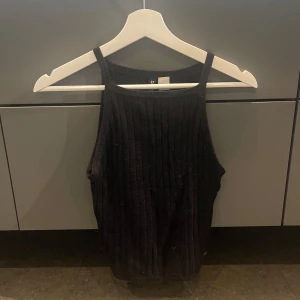 Svart ribbad linnetopp - Snygg svart ribbad linnetopp med smala axelband. Väldigt skönt material, mycket bra skick!❤️