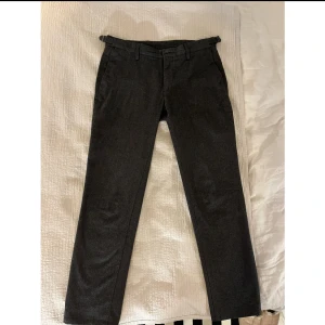 Grå kostymbyxor från Massimo Dutti - Mörkgråa kostymbyxor i 75% ull från Massimo Dutti säljes. I oerhört fint och absolut nyskick, använda 2 gånger och sedan hängt i gardereoben. Bältesöglor + sidojusterare. Storlek 31 i midjan, med klassisk passform. Längd är som en klassisk 31x32.