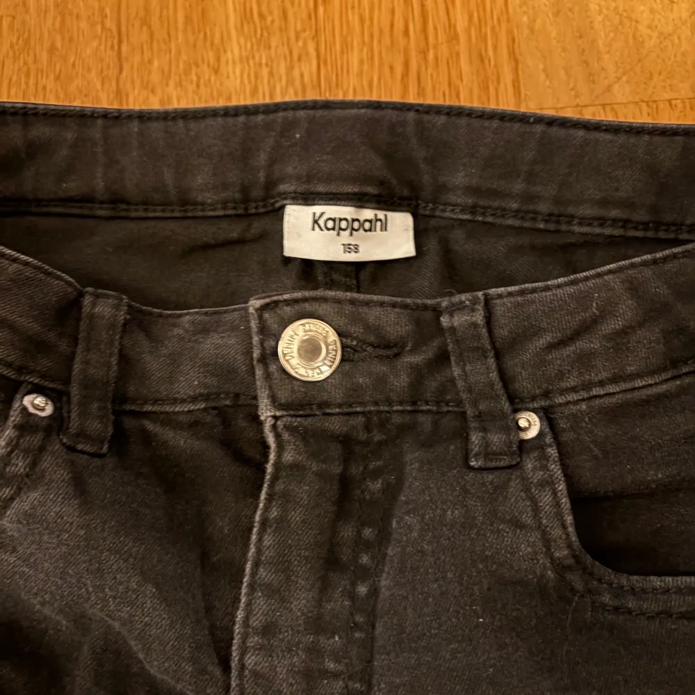 Snygga svarta jeans från Kappahl i storlek 158. Klassisk design med knapp och dragkedja framtill. Perfekta för en stilren look.. Farkut & Housut.