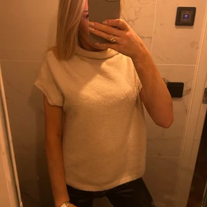Beige kortärmad tröja stickad - Säljer denna stickade toppen från Lindex i beige, använd tax 3 gnr så väldigt fint skick.