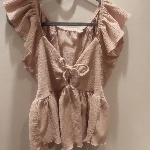 Rosa sommar tröja med rosett - Här är en sosa tröja i tunt material som är perfekt för sommaren.