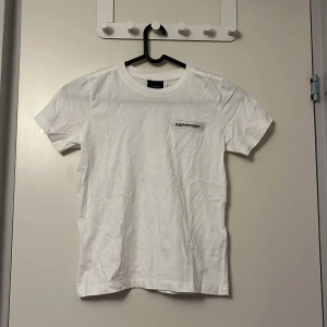 Vit t-shirt från Peak Performance - Säljer en klassisk vit t-shirt från Peak Performance med korta ärmar och en stilren logga på bröstet. Perfekt för en avslappnad stil.