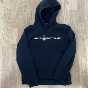 Svart hoodie Sail Racing - Säljer en svart hoodie från Sail Racing. Storlek 160. Jättesnygg och är i bra skick. Väldigt lite urtvättad. Pris kan 100% diskuteras 👍🙏.