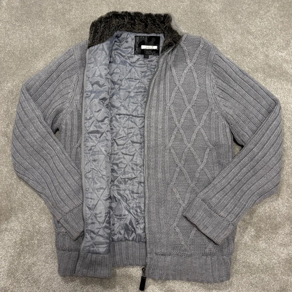 Säljer denna asfeta grå stickade Cardigan med pälskrage och fodring i hela jackan! Cardiganen är grymt skick, inga defekter! Size M, sitter tts. Modellen på bilden är 182cm lång ish. Skriv vid funderingar!. Neuletakit & Villapaidat.