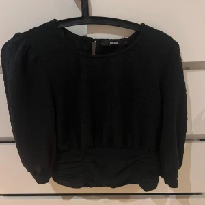 Svart blus från Bik Bok - Snygg svart blus från Bik Bok med trekvarts ärmar och dragkedja i sidan. Blusen har en elegant design som passar till många tillfällen. Köpte den för 349kr säljer den för 140+frakt 