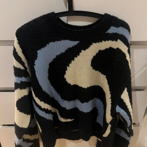 Mönstrad tröja från Vero Moda - Säljer en cool tröja från Vero Moda med ett abstrakt mönster i svart, blått och beige. Tröjan har långa ärmar och en rund halsringning. Den är även jätte tjock och varm, passar mig som brukar ha S/M i stockade tröjor. Köpte den för 349kr säljer den för 175+frakt 