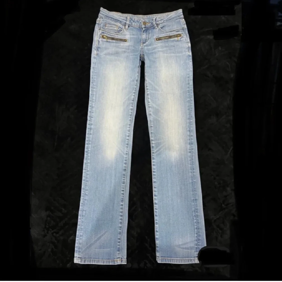 Ljusblå jeans med dragkedjedetaljer