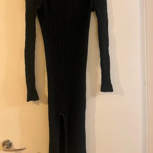 Svart ribbad klänning från ONLY - Säljer en svart ribbad klänning från ONLY i storlek XS. Klänningen har en tight passform och långa ärmar samt en slits, perfekt för höst och vinter. Den är stilren och enkel, vilket gör den lätt att matcha med olika accessoarer. Perfekt för både vardag och fest!