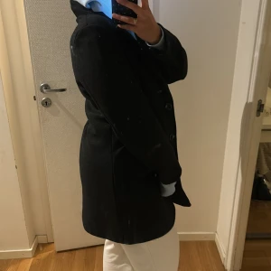 Svart kappa  - Säljer denna fina svarta kappa som är i helt nytt skick, den är använd 1 gång påväg till bröllop sen har den inte kommit till någon användning mer än så. 