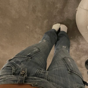 Blå jeans med slitningar - Säljer ett par snygga blå jeans med slitningar. De har en avslappnad passform och är bra skick. Perfekta och passar till allt. Lågmidjade, pris kan diskuteras