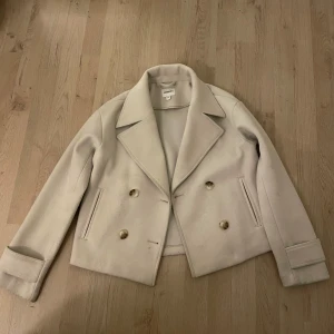 Beige kappa - Säljer en beige kappa, den är använd ett fåtal gånger och det finns inga slitage på den. 