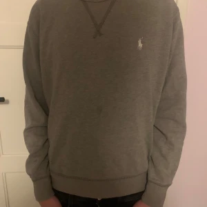 Grå Ralph Lauren Tröja - Säljer en grå tröja från Polo Ralph Lauren, tröjan har en normal passform och ör självfallet äkta. Modellen i bilden är ungefär 170 cm lång och väger 52 KG. Tröjan är Large i barnstorlek, alltså är de en barntröja och inte en vuxen tröja. Tveka inte att skriva vid frågor!🙂👍